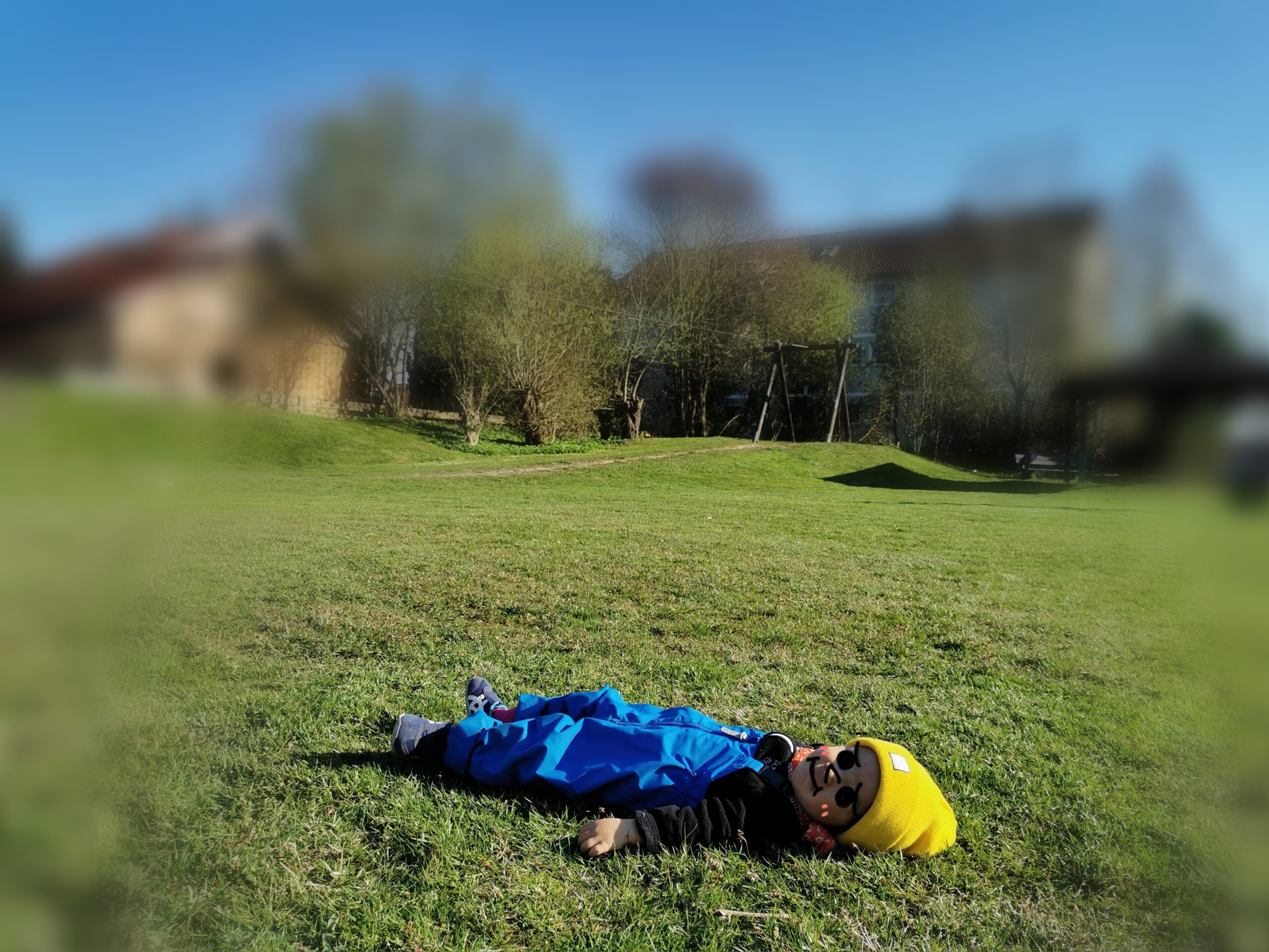 芝生に寝そべる小さな男の子